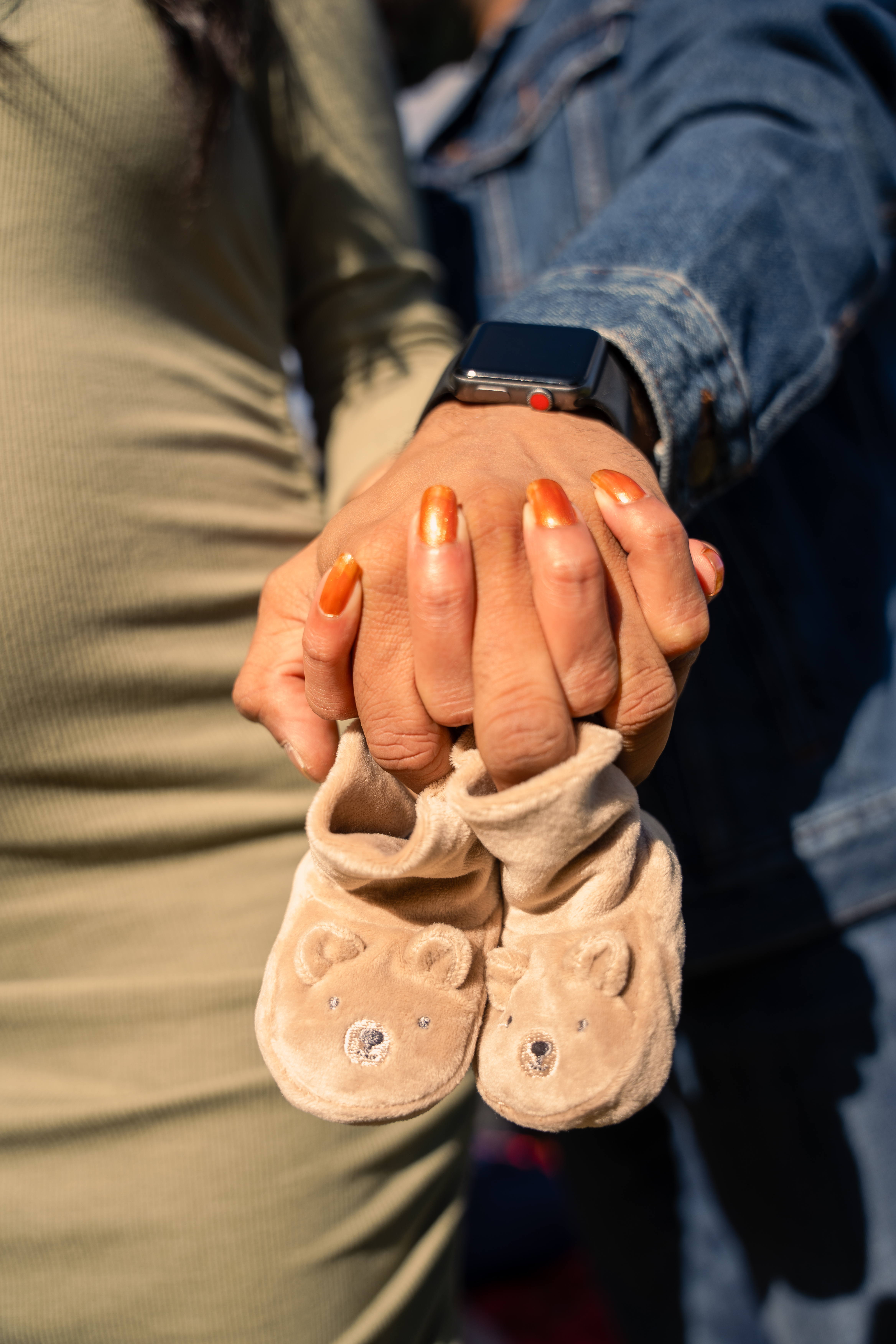Couple holding baby shoes
